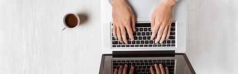 Mains calculant un budget locatif sur un clavier d'ordinateur