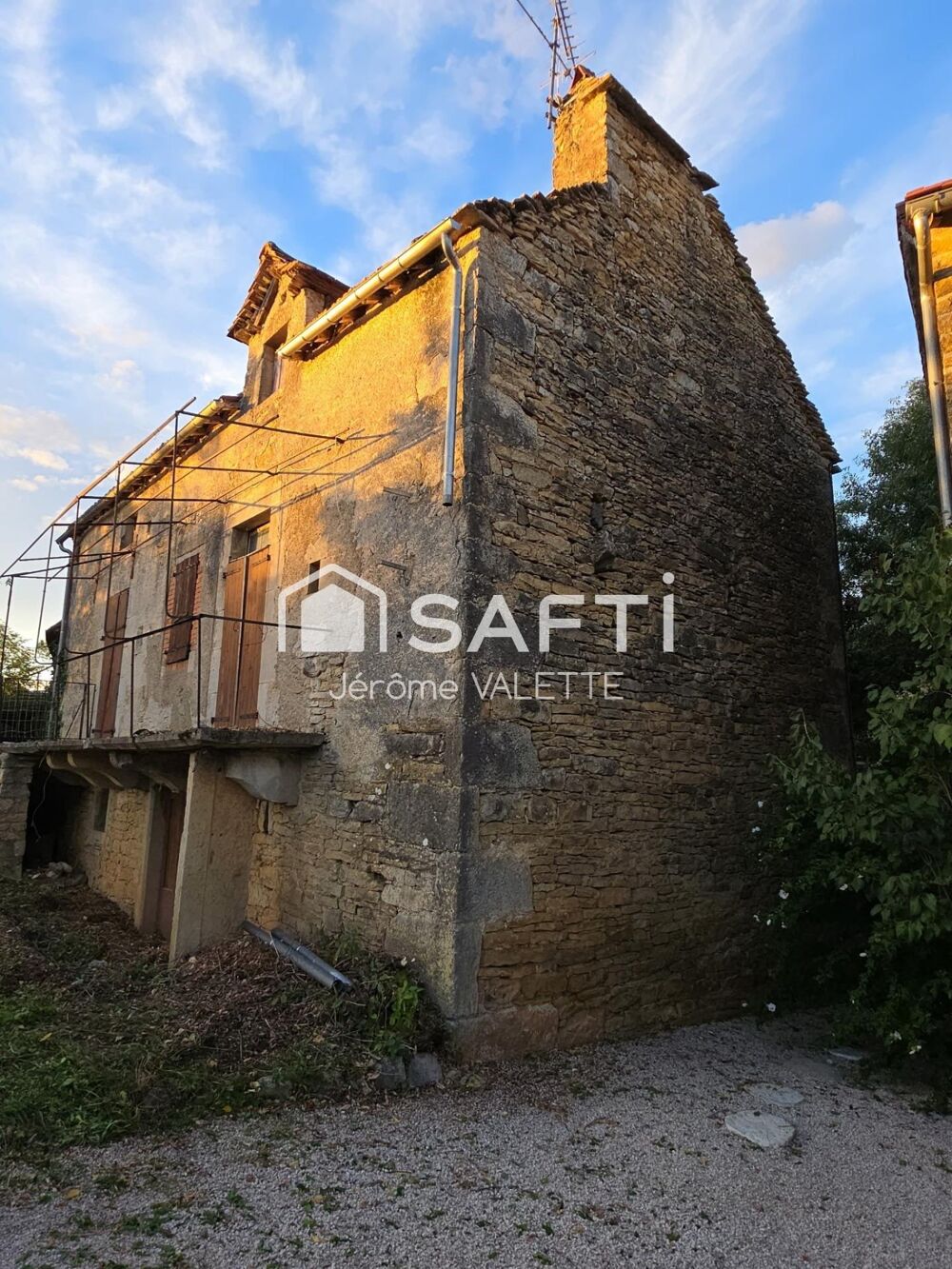Maison en pierre avec grange attenante.