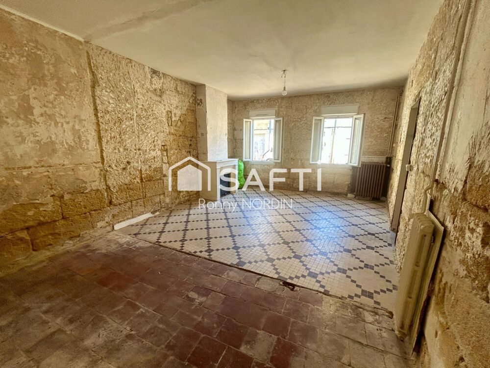 Maison en pierre à rénover, idéalement située au coeur de Castillon, avec jardin et beau potentiel daménagement.