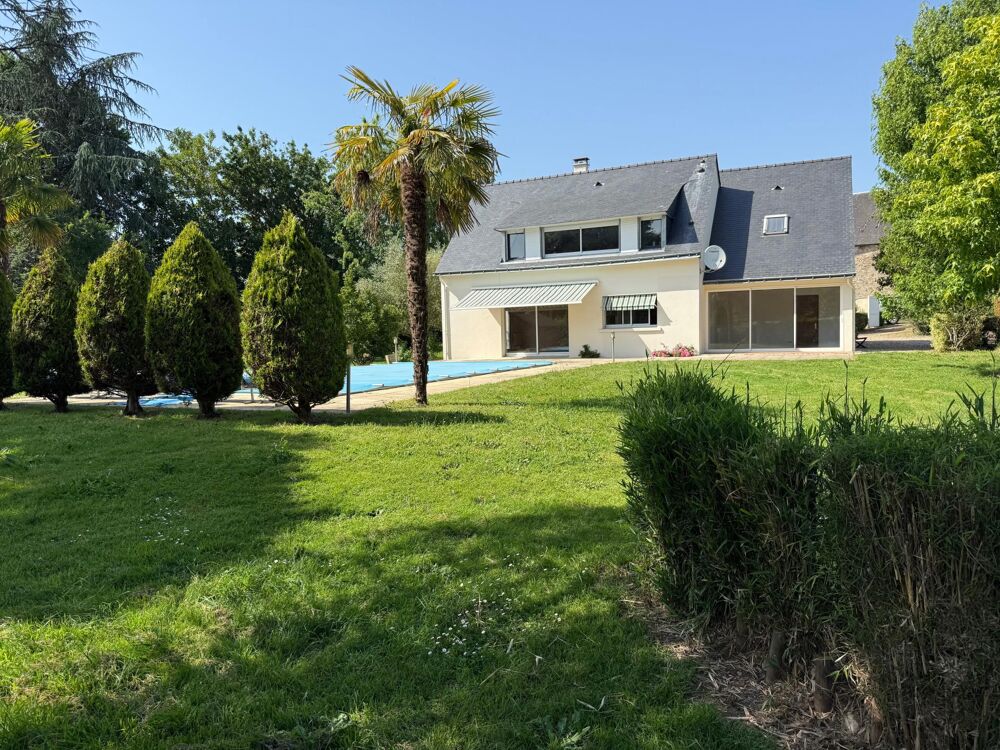 Maison spacieuse avec piscine et terrain arboré.