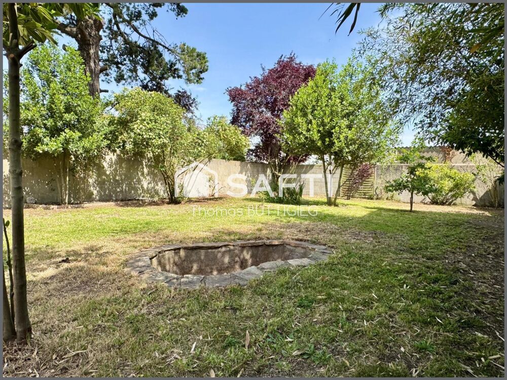 Maison de ville avec garage et jardin.