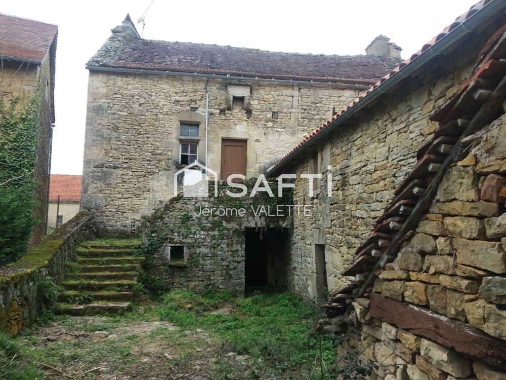 Maison en pierre avec grange attenante.