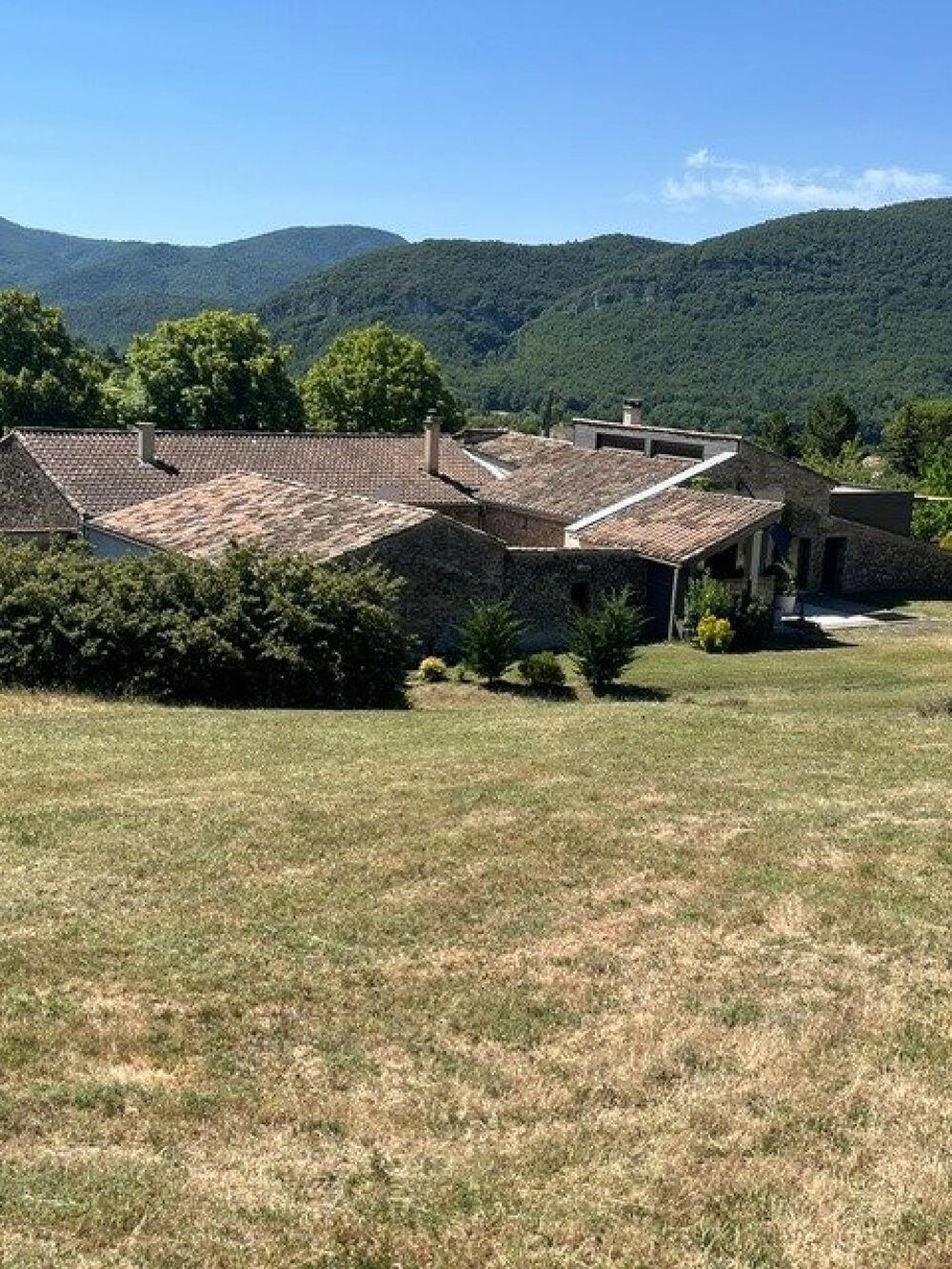 Ancienne ferme rénovée sur un domaine attenant de 12 hectares avec source, vue montagnes et potentiel multi-habitation