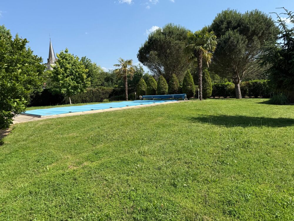 Maison spacieuse avec piscine et terrain arboré.
