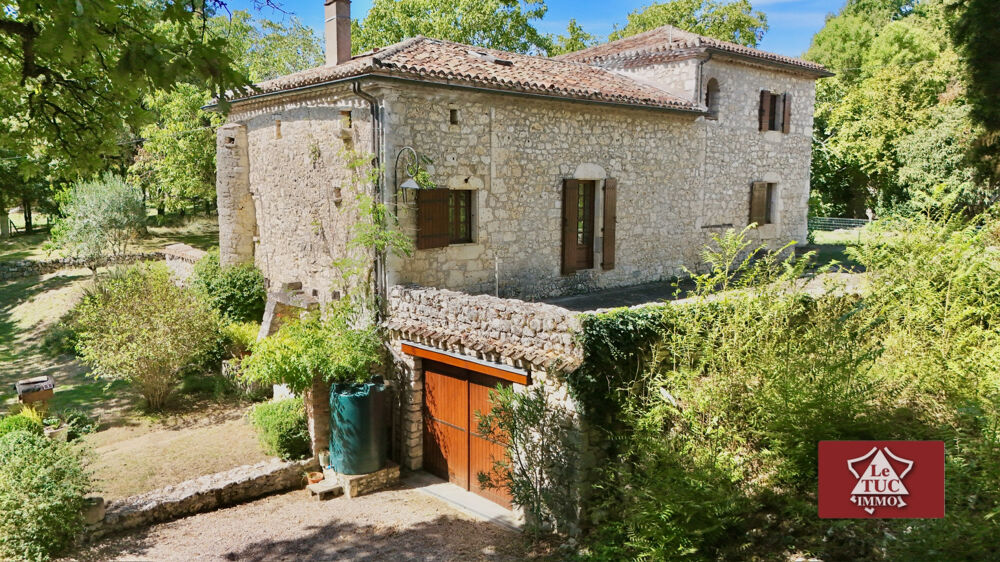 Maison en pierre avec garage, piscine et jardin.
