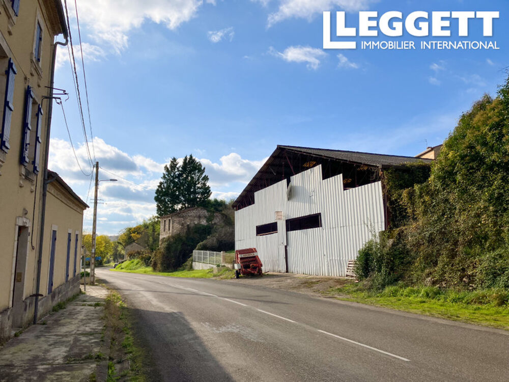 Grand garage avec jardin dans un village.