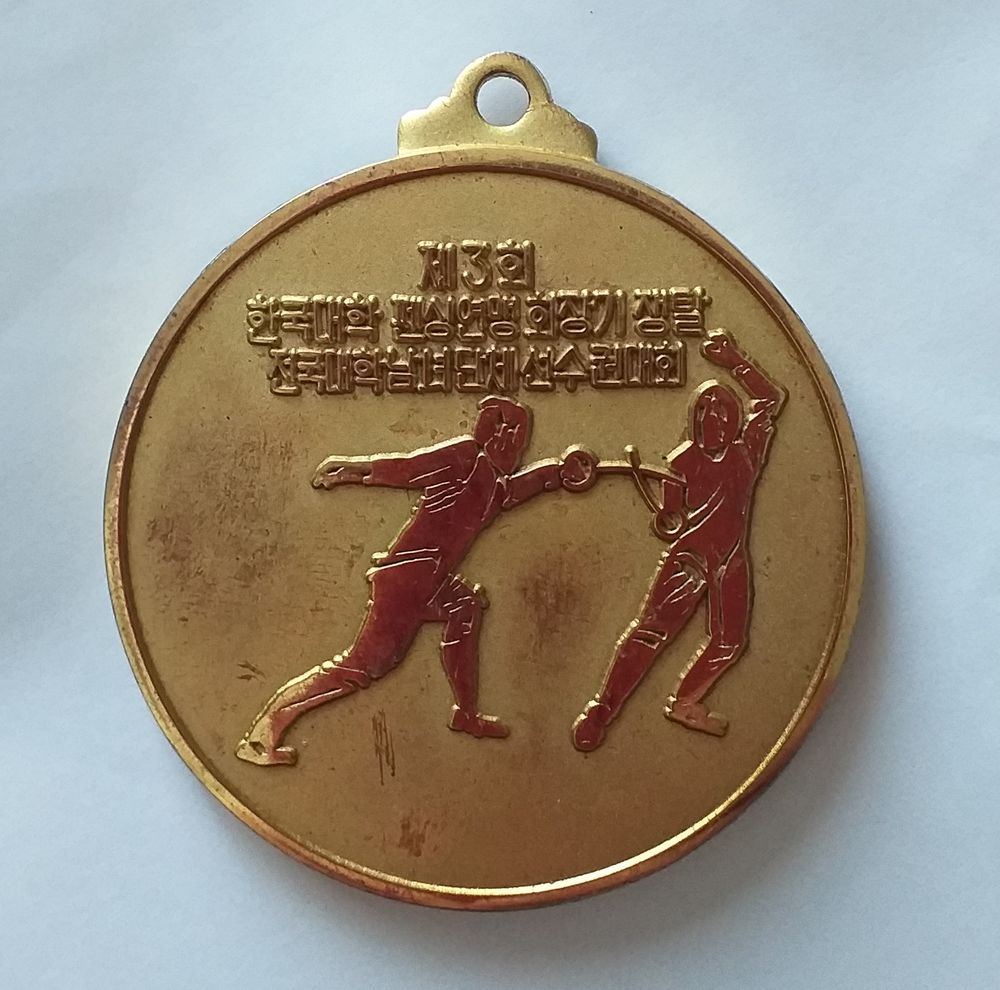 M&eacute;daille d'escrime dor&eacute;e (texte en langue asiatique) date 1984-12-1 