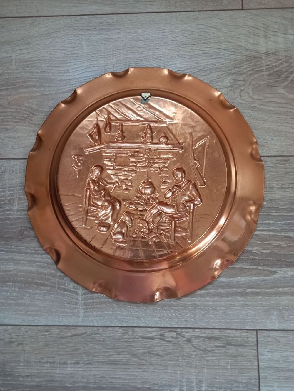 Assiette d&eacute;corative en cuivre "personnages au coin du feu". Décoration