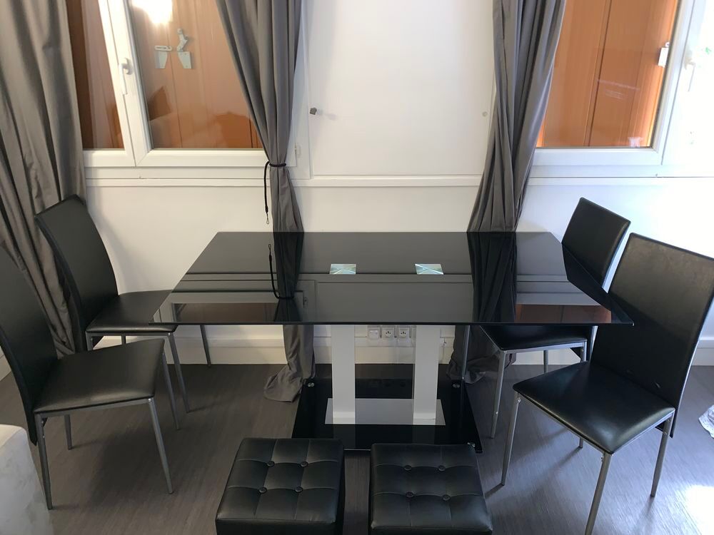 Une grande table en verre noir , 4 chaises et 2 poufs Meubles
