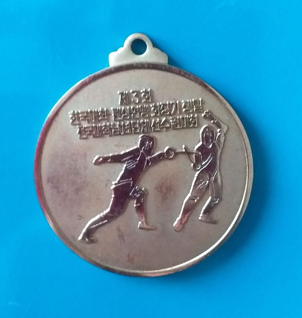 M&eacute;daille d'escrime dor&eacute;e (texte en langue asiatique) date 1984-12-1 