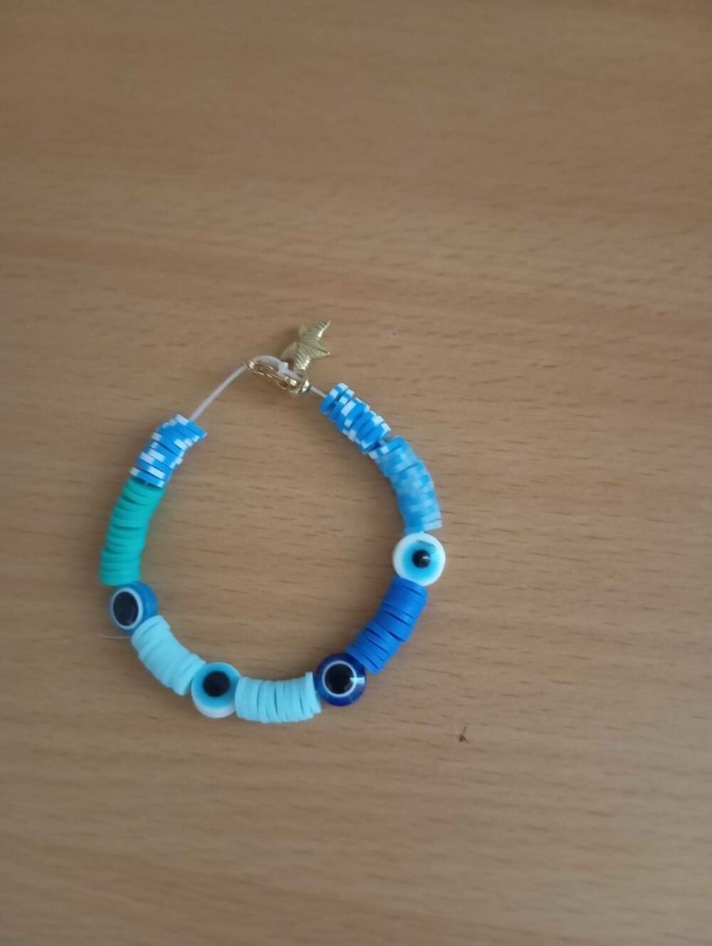 bracelet oeil et perles bleues avec une attache &eacute;toile dor&eacute;e Bijoux et montres