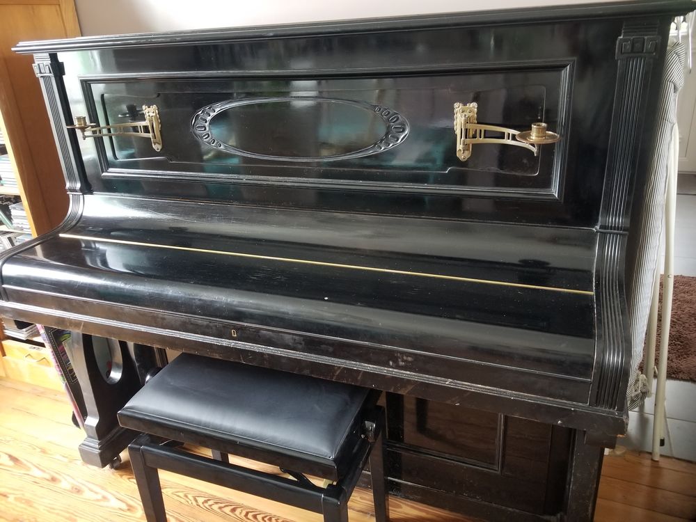 Piano droit noir laque de 1910 + tabouret reglable.
Instruments de musique