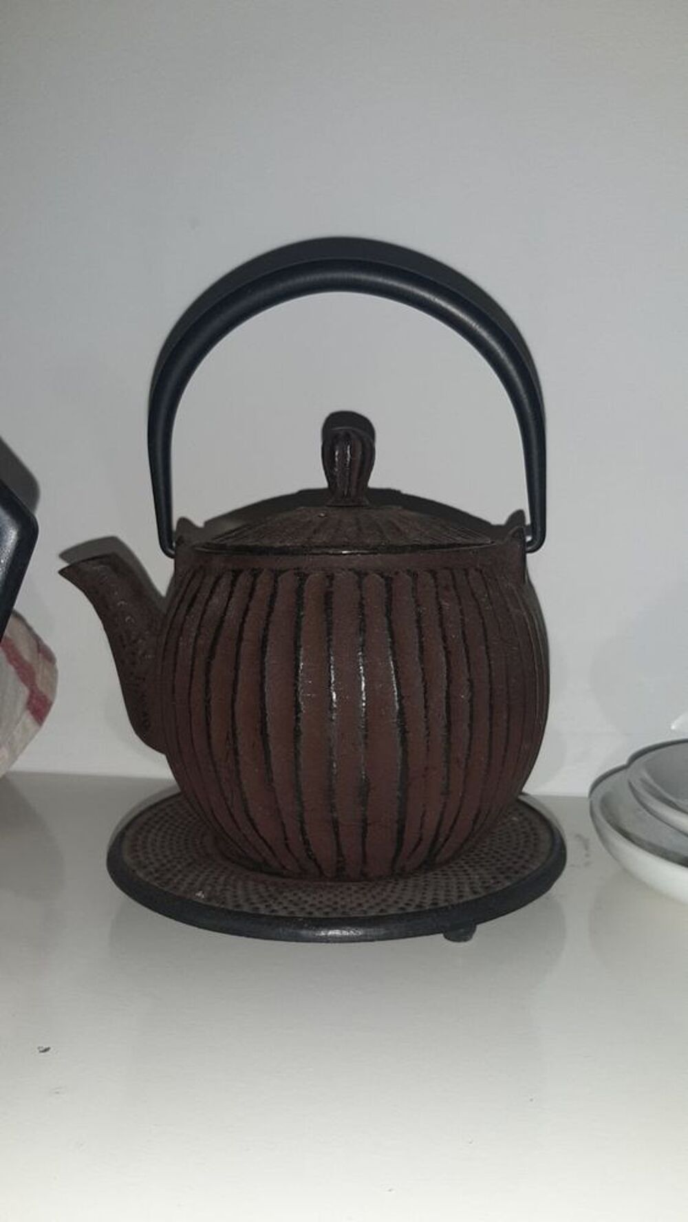 Th&eacute;i&egrave;re et sous plat japonais en fonte noire.
Décoration