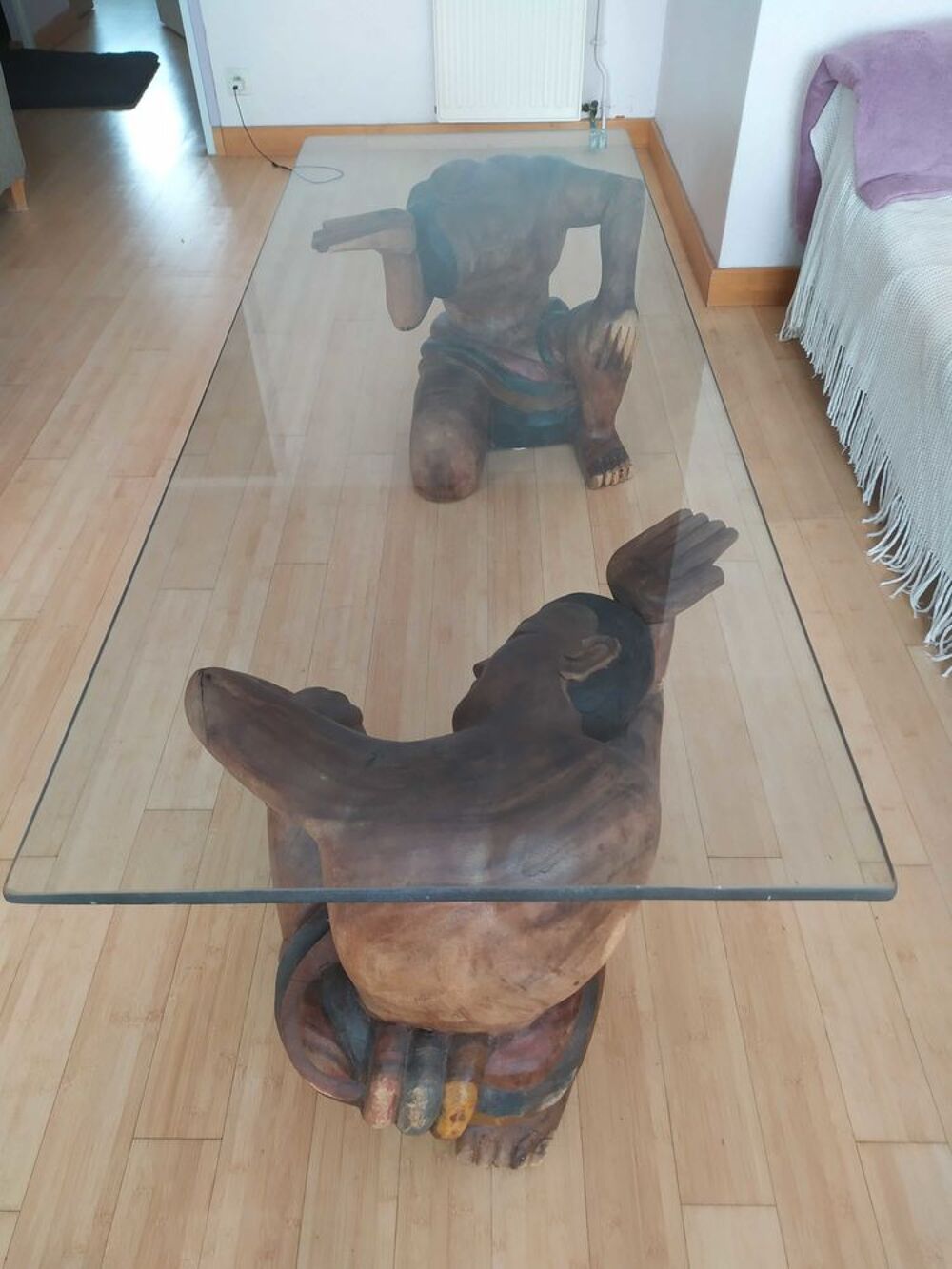 Table basse en verre avec statues bois. Meubles