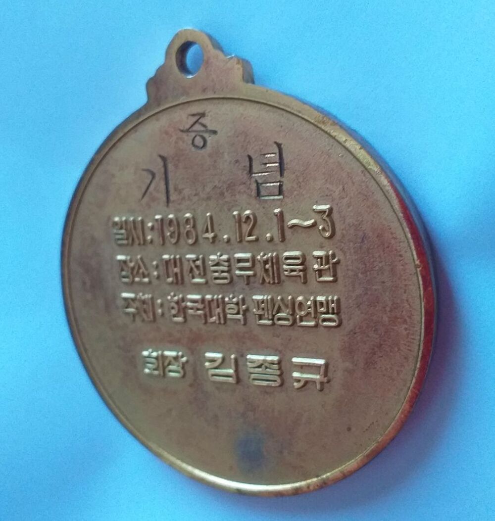 M&eacute;daille d'escrime dor&eacute;e (texte en langue asiatique) date 1984-12-1 