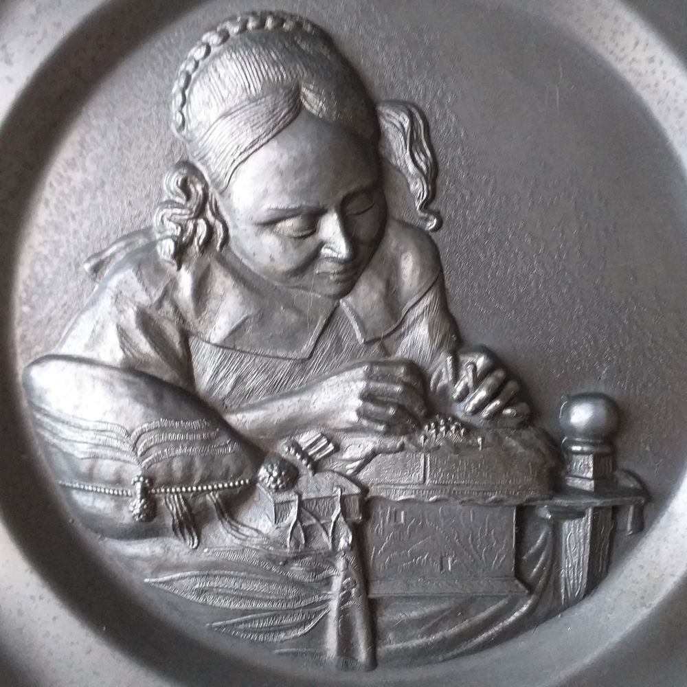  Assiette d&eacute;corative en &eacute;tain : femme effectuant des travaux manuels 