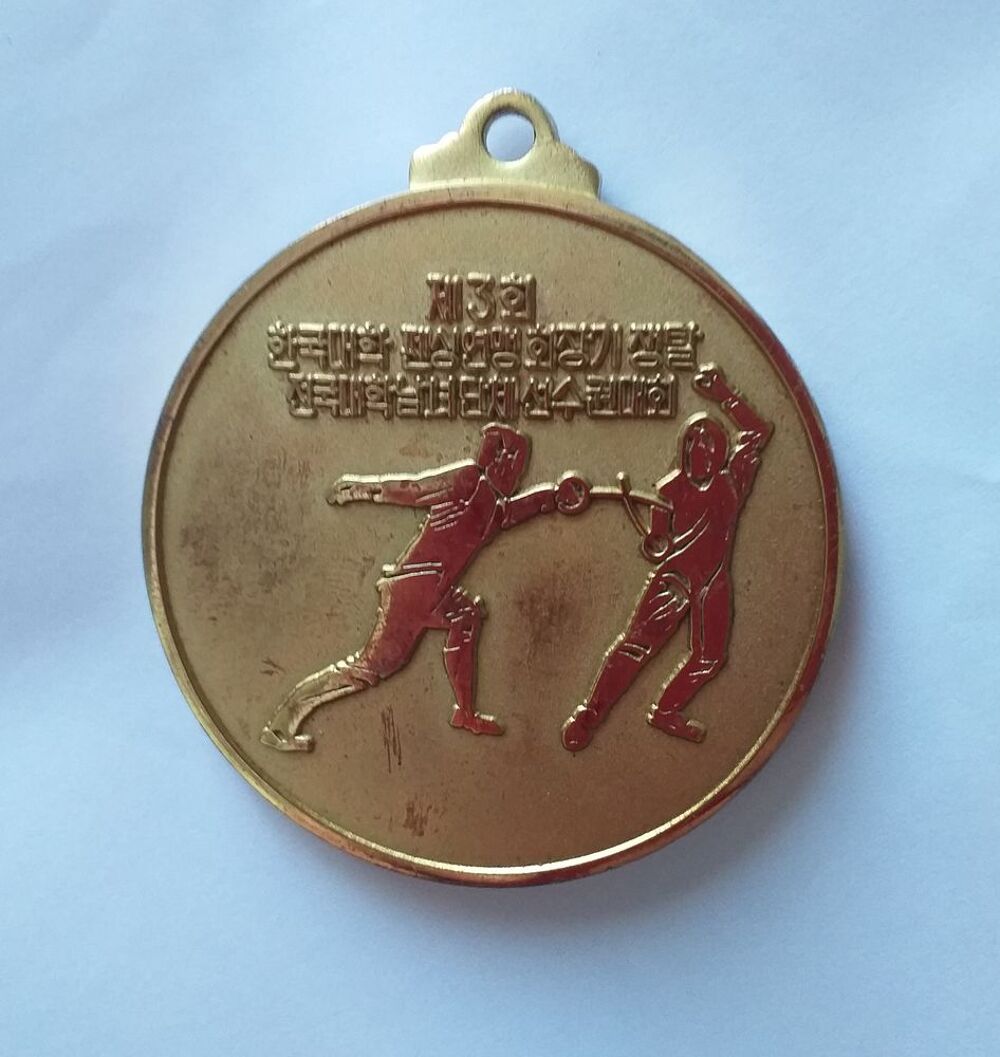 M&eacute;daille d'escrime dor&eacute;e (texte en langue asiatique) date 1984-12-1 
