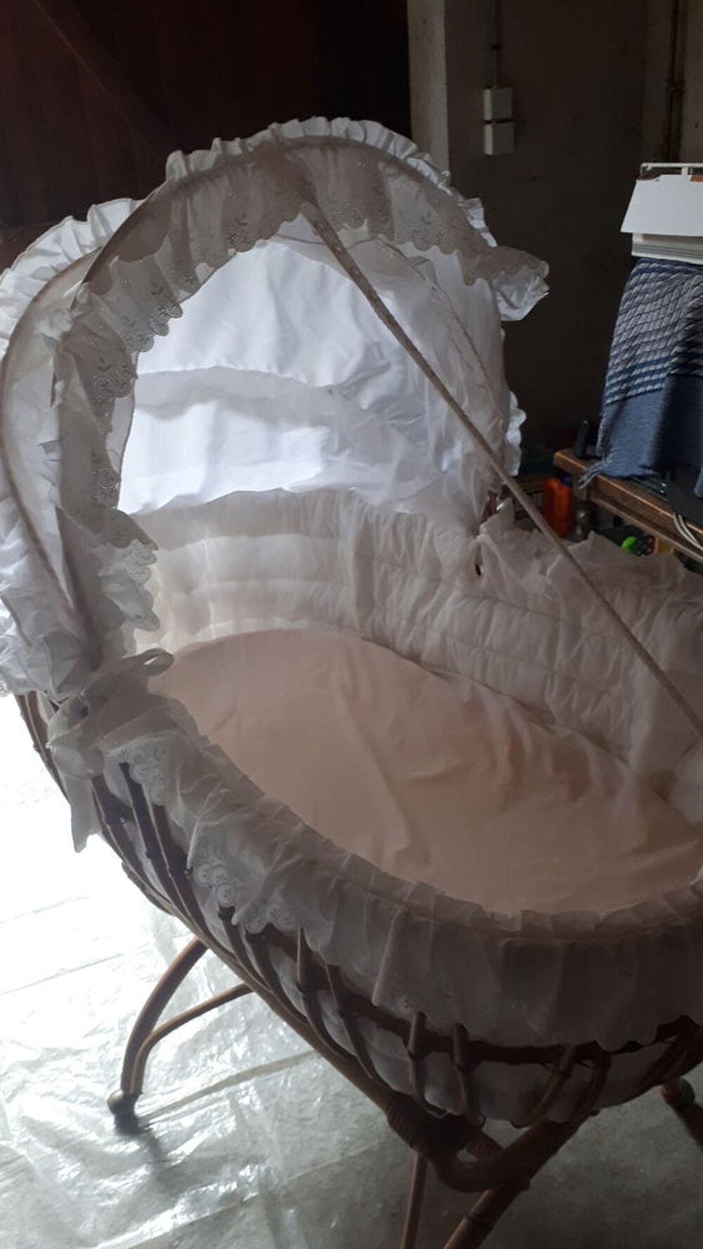 Berceau en rotin avec contour en dentelle blanche . Puériculture