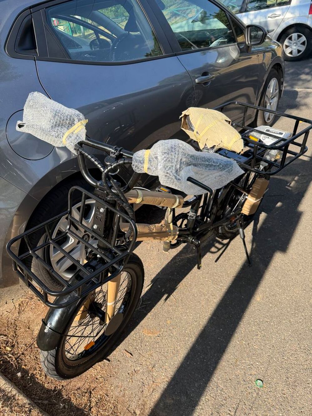 V&eacute;lo cargo noir avec porte-bagages avant et arri&egrave;re Vélos