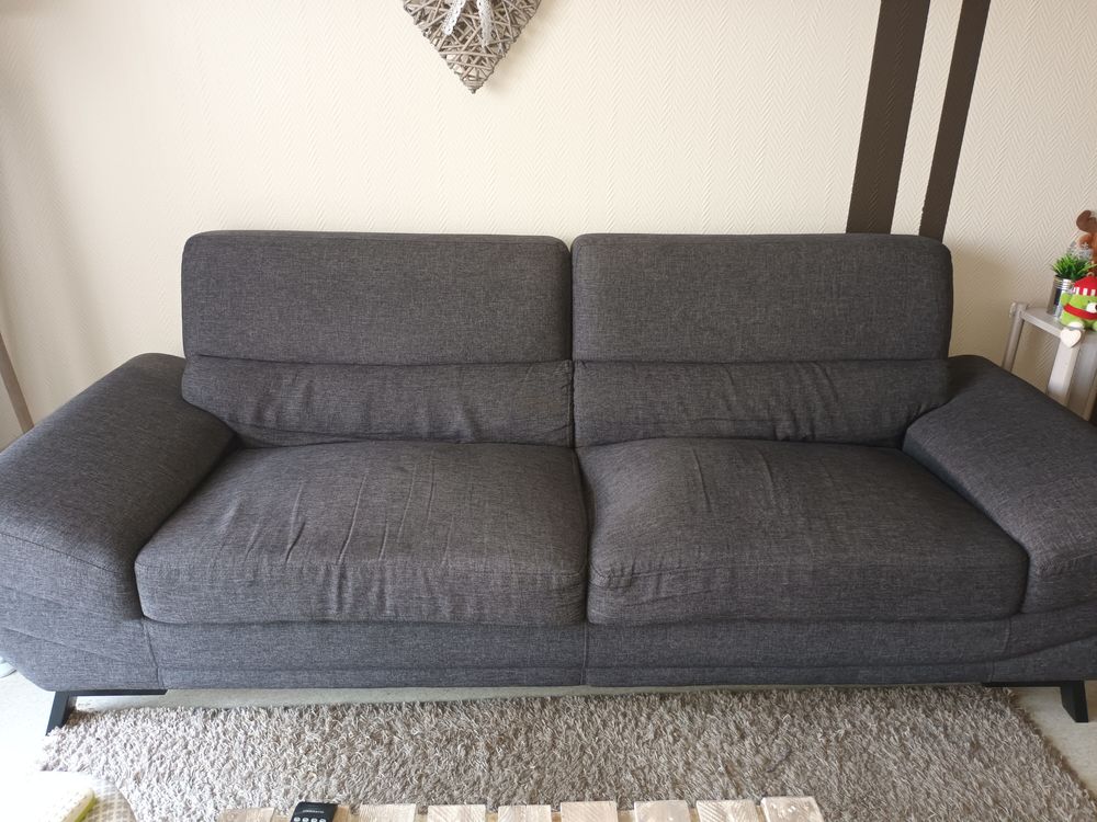 canap&eacute; gris avec un ressort cass&eacute; sur une assise Meubles