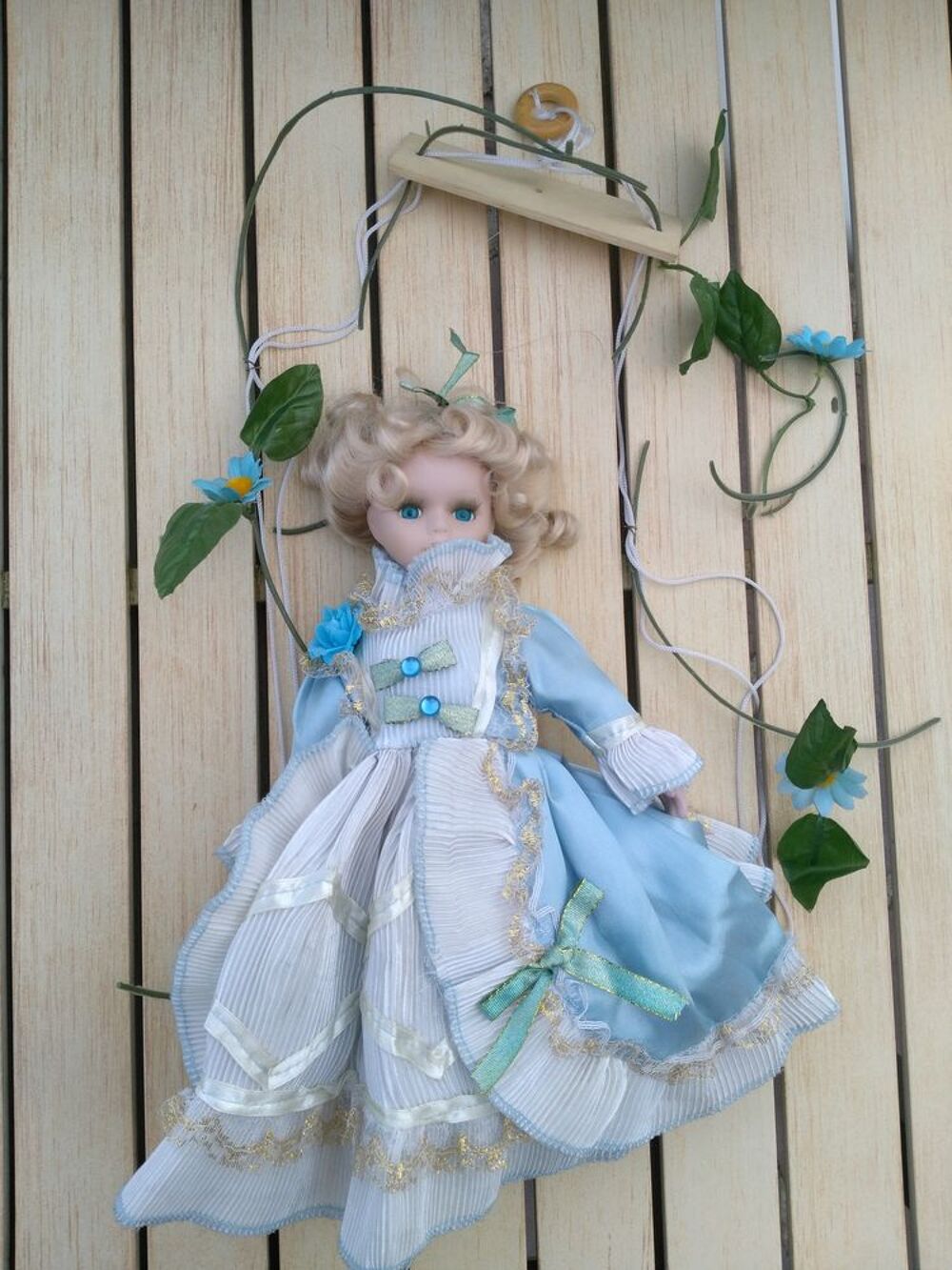 Poup&eacute;e en porcelaine sur balan&ccedil;oire
