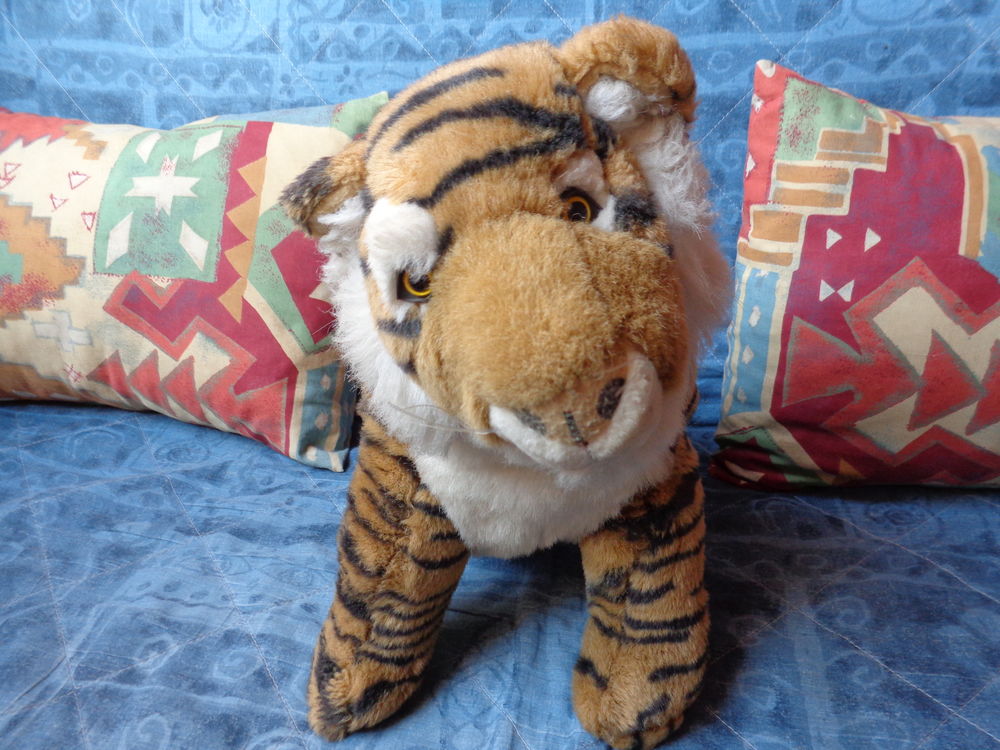 Tigre assis en peluche roux et blanc. Jeux / jouets