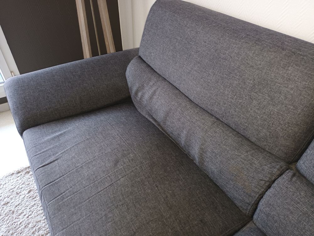 canap&eacute; gris avec un ressort cass&eacute; sur une assise Meubles