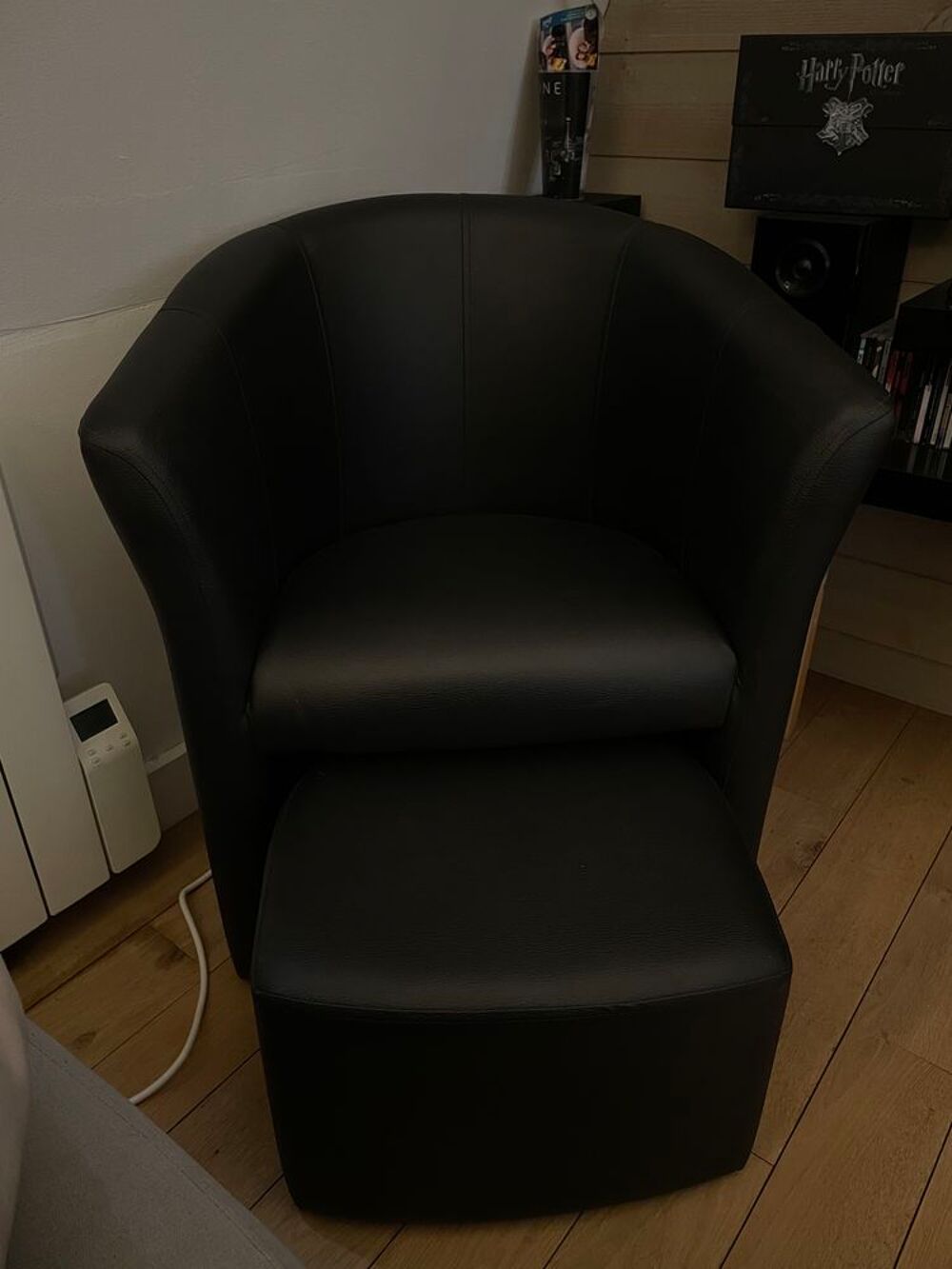 Fauteuil noir en cuir avec son repose pieds. Meubles