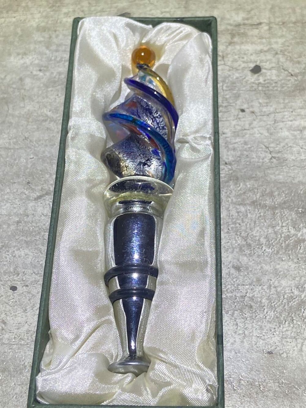 Il s'agit d'un &eacute;l&eacute;gant bouchon de bouteille d&eacute;coratif surmont&eacute; d'un verre torsad&eacute; aux reflets bleus et argent&eacute;s. Décoration