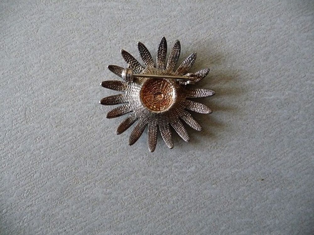 Broche m&eacute;tal et strasses forme marguerite Bijoux et montres