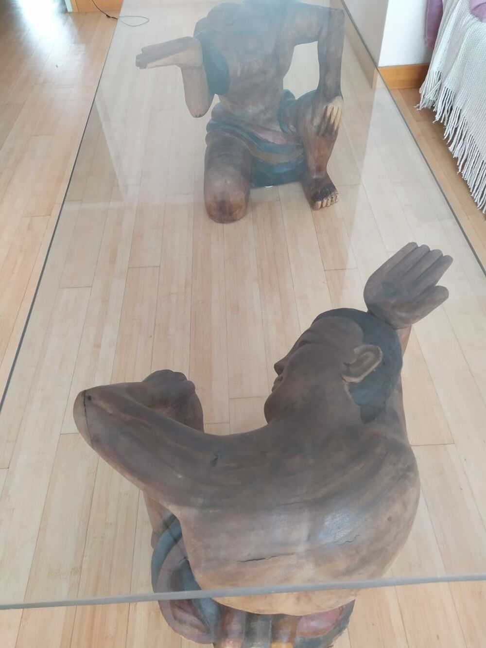 Table basse en verre avec statues bois. Meubles