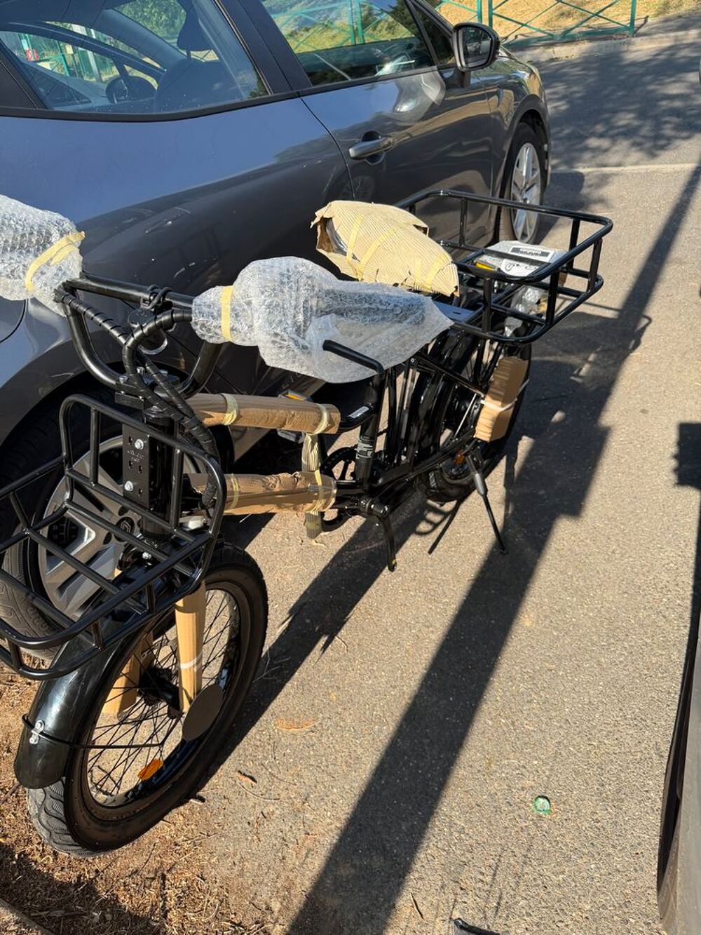 V&eacute;lo cargo noir avec porte-bagages avant et arri&egrave;re Vélos