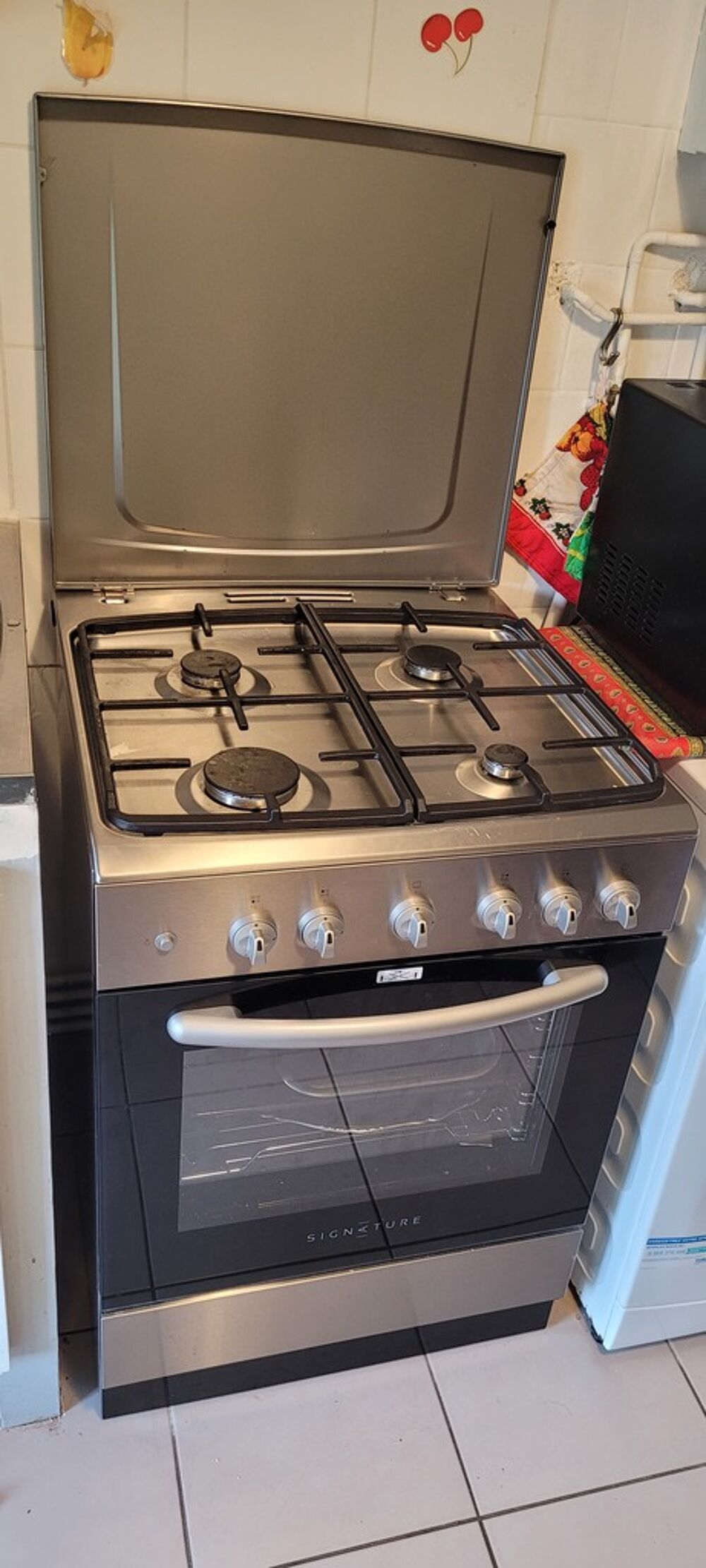 Cuisini&egrave;re gaz inox avec four Marque : Signature. Electroménager