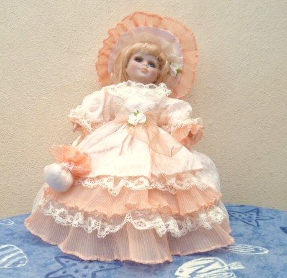 Poup&eacute;e porcelaine sur coussin 
