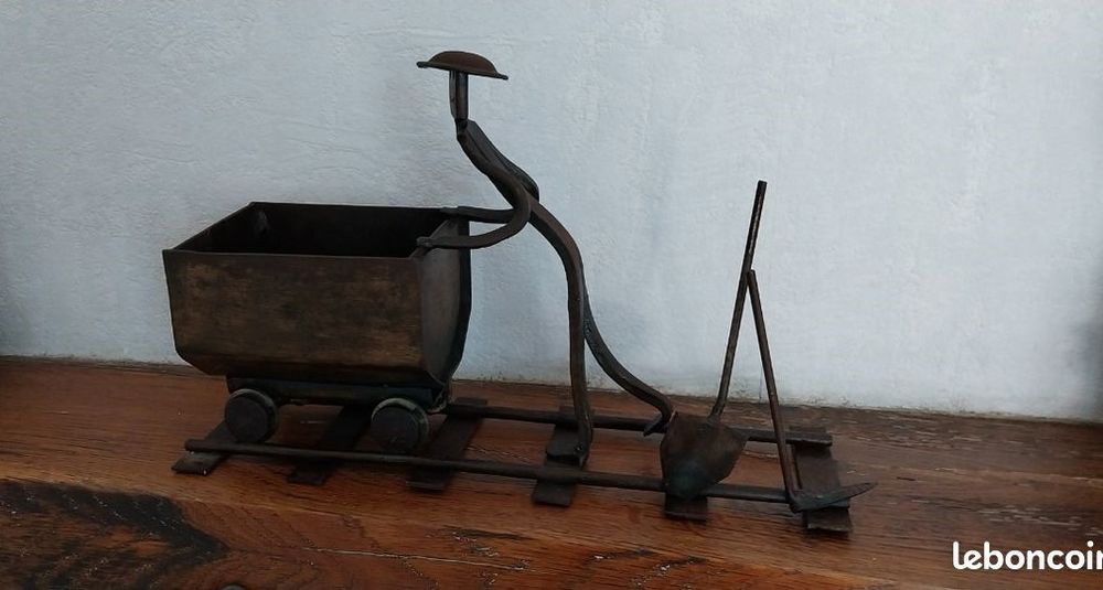 scupture de mineur poussant une berline de charbon 