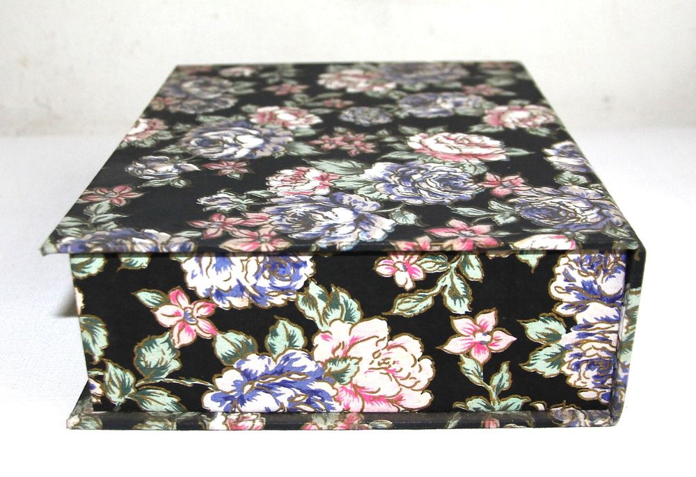 Boite &agrave; bijoux en tissu motif roses sur fond noir.
Bijoux et montres