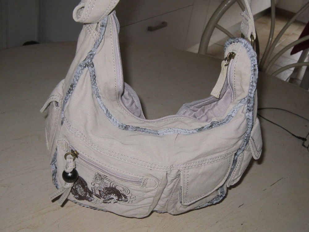 Une petite besace en tissu de couleur beige Maroquinerie