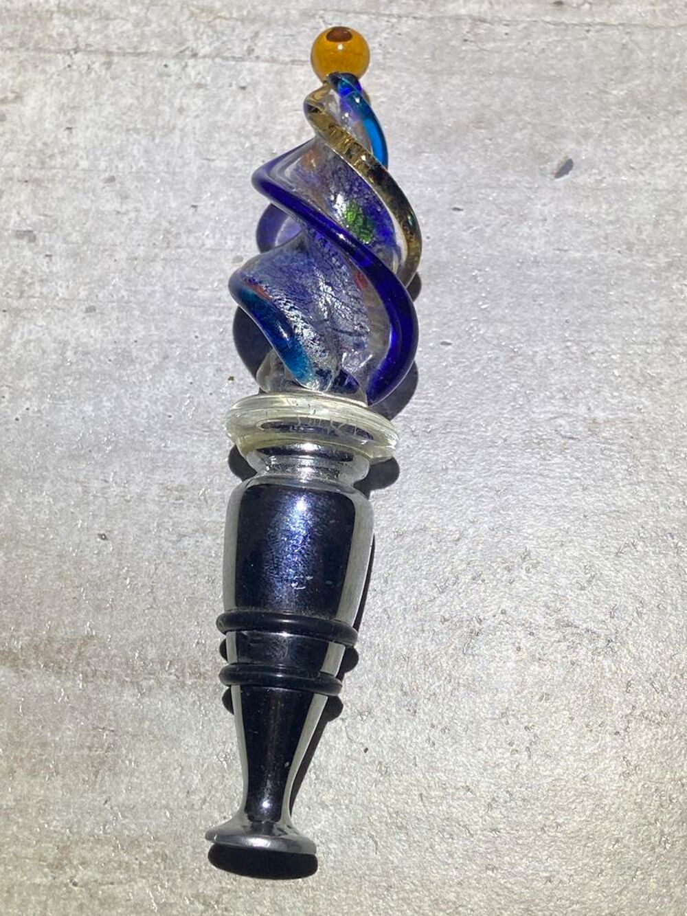 Il s'agit d'un &eacute;l&eacute;gant bouchon de bouteille d&eacute;coratif surmont&eacute; d'un verre torsad&eacute; aux reflets bleus et argent&eacute;s. Décoration