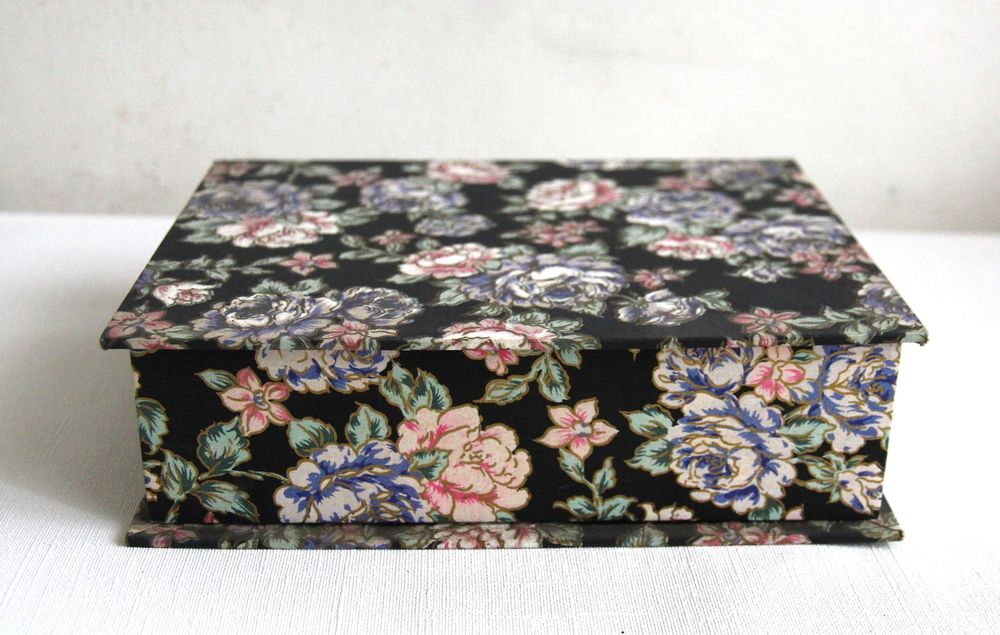 Boite &agrave; bijoux en tissu motif roses sur fond noir.
Bijoux et montres